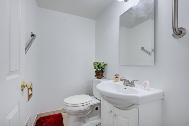 bathroom with toilet, tile patterned flooring, and vanity