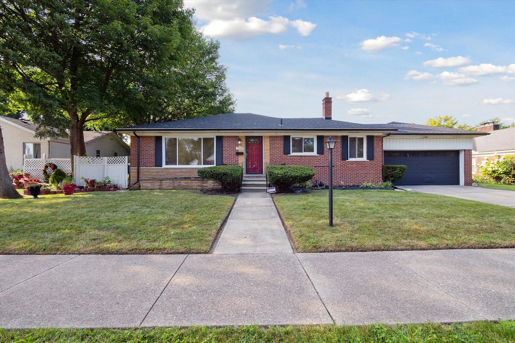 ranch-style house featuring a garage and a front lawn