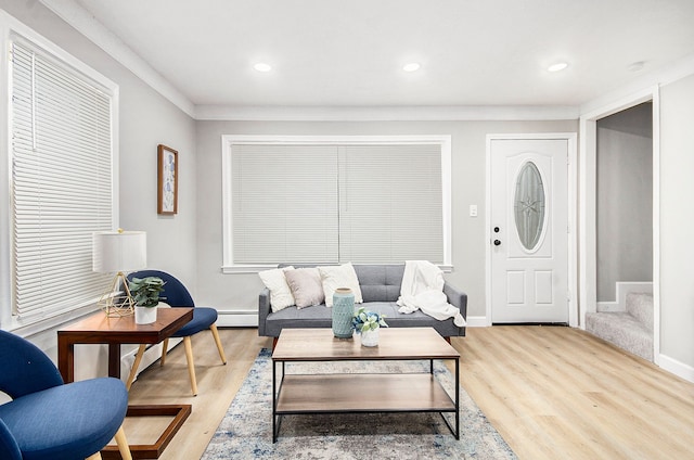 living room with a baseboard heating unit and light hardwood / wood-style flooring