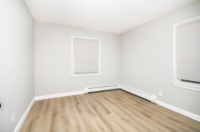 empty room with light wood-type flooring and baseboard heating