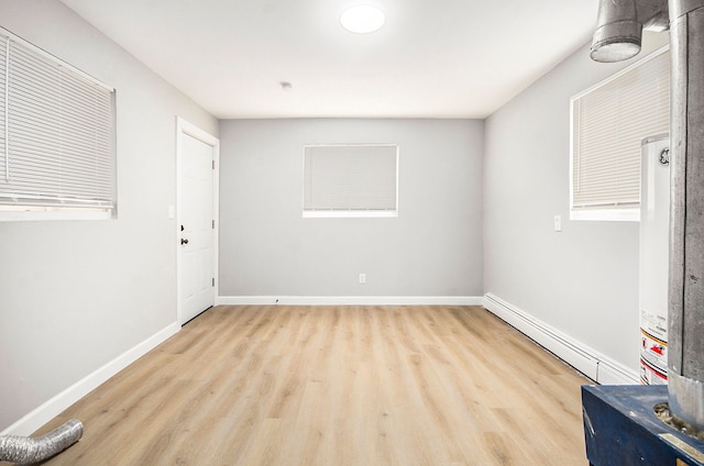 unfurnished room with light hardwood / wood-style floors and a baseboard radiator