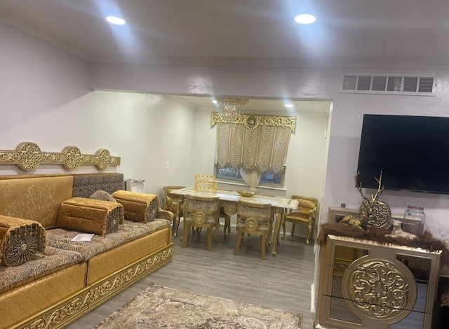 living room with wood-type flooring and ornamental molding