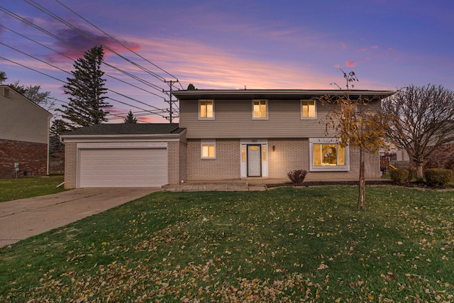 front facade featuring a garage and a yard