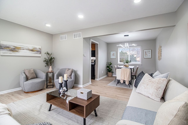 living room featuring light hardwood / wood-style floors and a notable chandelier