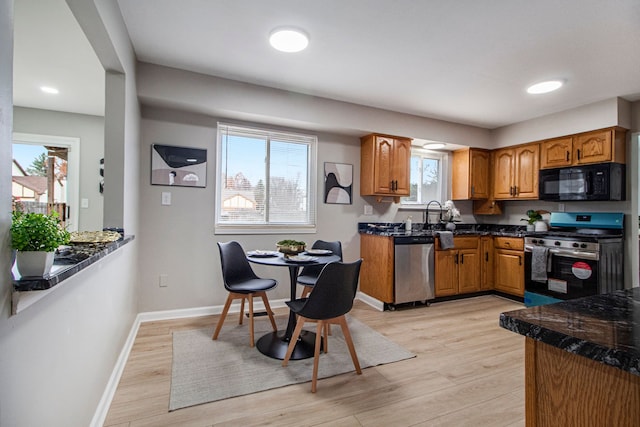 kitchen with sink, appliances with stainless steel finishes, and light hardwood / wood-style flooring