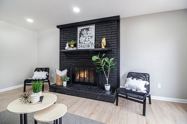 sitting room featuring a fireplace and hardwood / wood-style floors