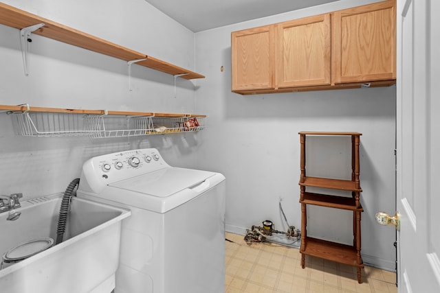 laundry area featuring sink, washer / dryer, and cabinets