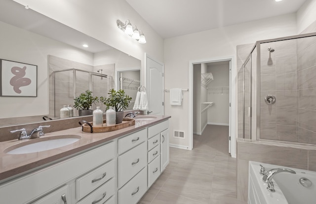 bathroom with tile patterned floors, vanity, and shower with separate bathtub