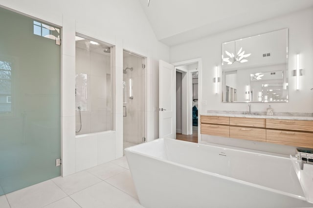 bathroom featuring tile patterned floors, vanity, separate shower and tub, and lofted ceiling