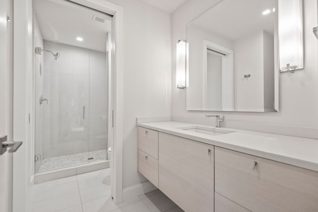 bathroom featuring tile patterned floors, toilet, vanity, and walk in shower