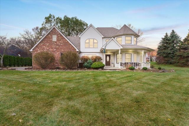 view of front facade featuring covered porch and a lawn