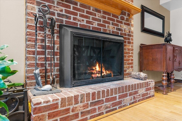 room details featuring a brick fireplace and wood-type flooring