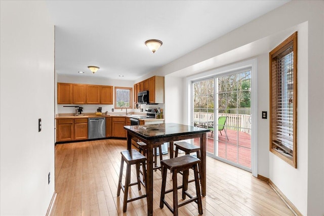 kitchen featuring stainless steel appliances, sink, and light wood-type flooring