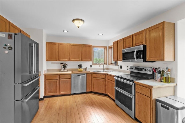 kitchen with sink, light hardwood / wood-style floors, and appliances with stainless steel finishes