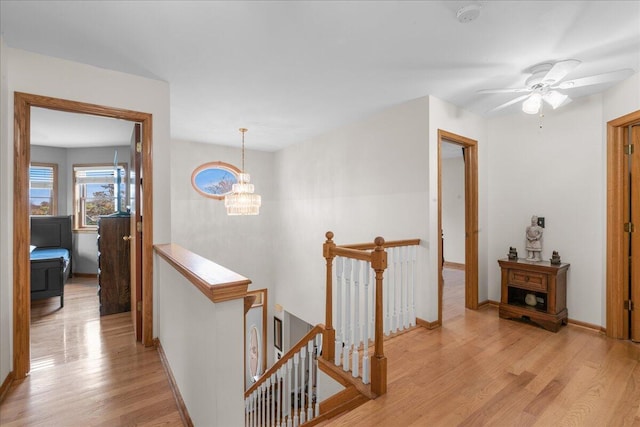 hall with an inviting chandelier and light wood-type flooring