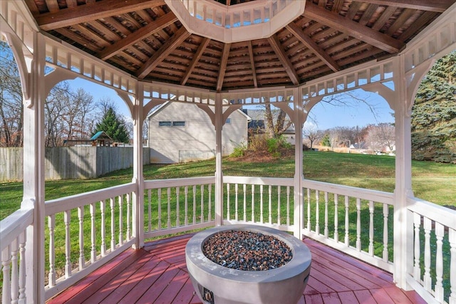 wooden deck featuring a lawn, a gazebo, and a fire pit