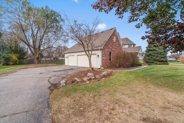 view of home's exterior featuring a garage and a lawn