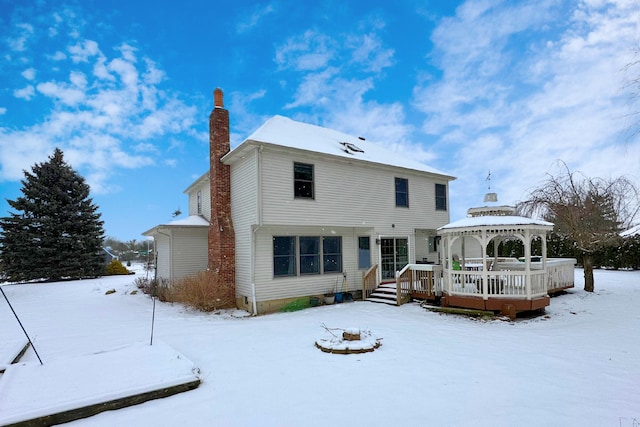 snow covered back of property featuring a gazebo and a deck