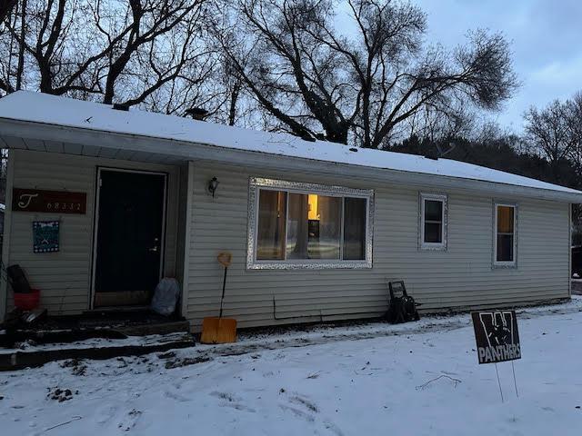 view of snow covered back of property