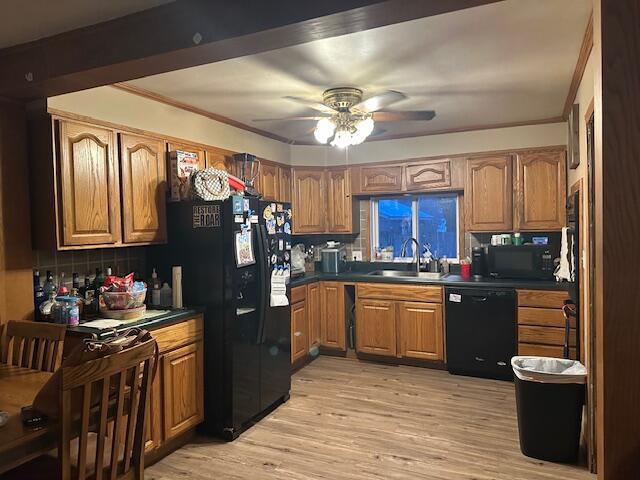 kitchen featuring backsplash, ornamental molding, sink, black appliances, and light hardwood / wood-style floors