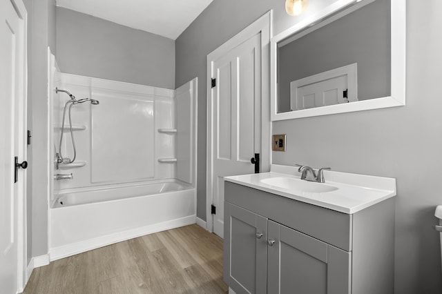 bathroom with wood-type flooring, shower / bath combination, and vanity