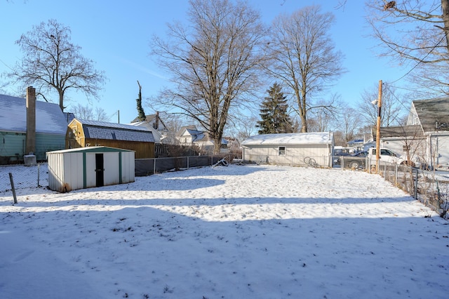 snowy yard with a storage shed