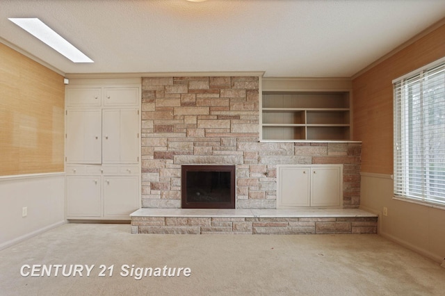 unfurnished living room featuring a textured ceiling, a stone fireplace, and light carpet