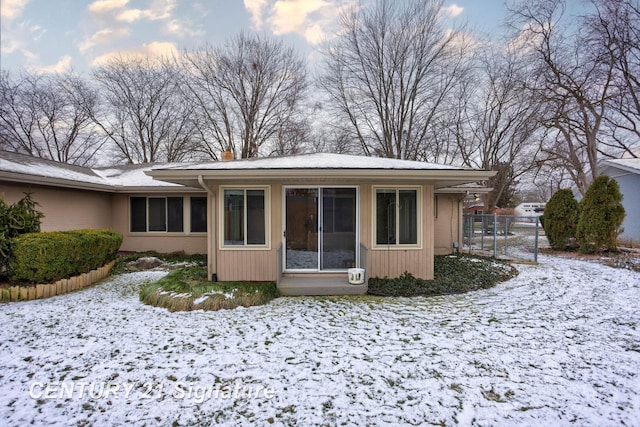 view of snow covered rear of property