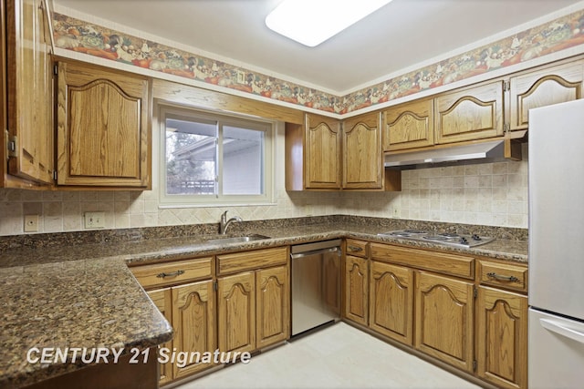 kitchen with backsplash, sink, appliances with stainless steel finishes, and dark stone counters