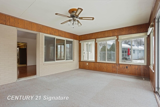 unfurnished sunroom featuring ceiling fan