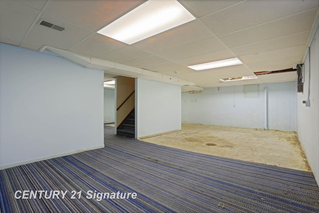 basement featuring a paneled ceiling and carpet floors