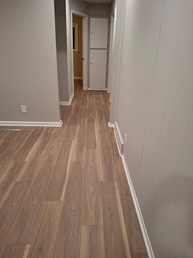 hallway with wood finished floors and baseboards