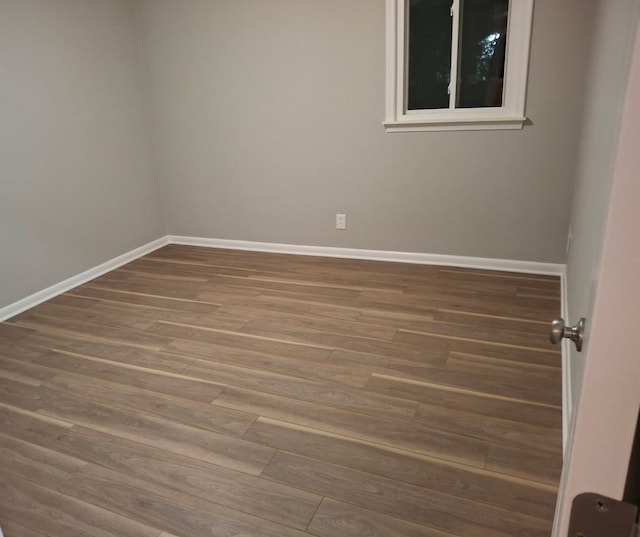 empty room featuring baseboards and wood finished floors