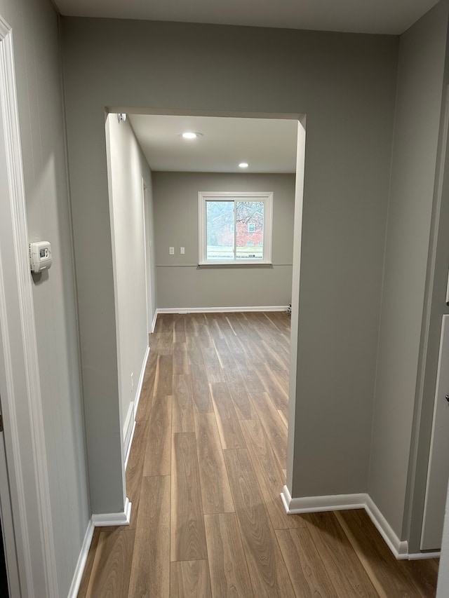 hallway with recessed lighting, wood finished floors, and baseboards