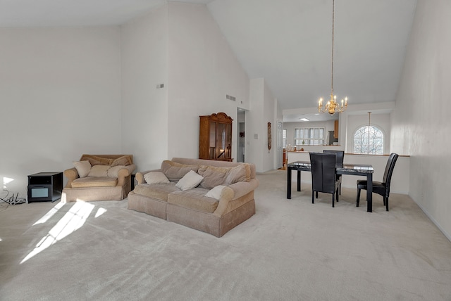 carpeted living room featuring high vaulted ceiling and a notable chandelier