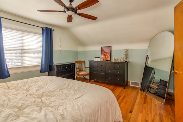 bedroom with ceiling fan, lofted ceiling, and light wood-type flooring