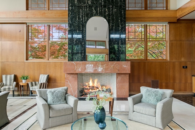 sitting room featuring wood walls and a towering ceiling