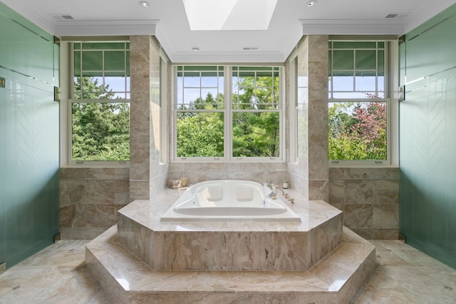 bathroom with a skylight, ornamental molding, and tiled tub