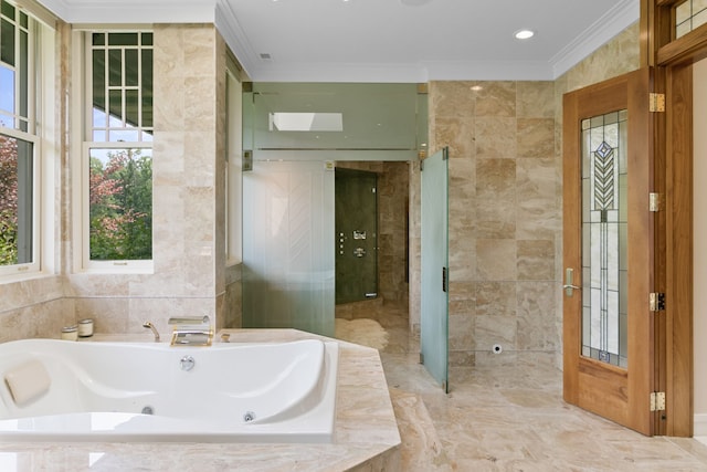 bathroom with crown molding, a relaxing tiled tub, and tile walls