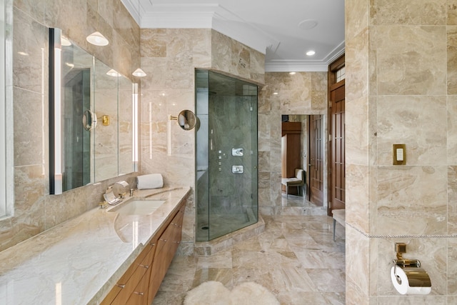 bathroom featuring vanity, an enclosed shower, ornamental molding, and tile walls