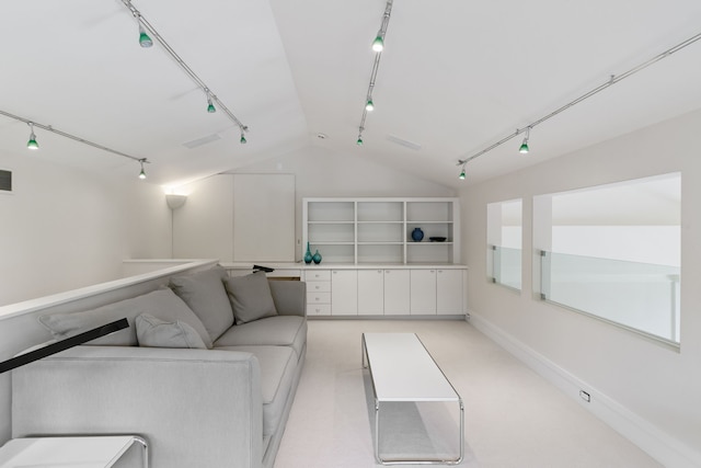 carpeted living room with rail lighting and lofted ceiling