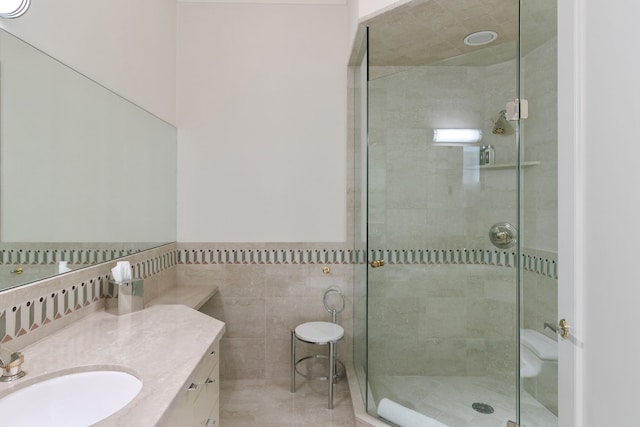 bathroom with vanity, a shower with shower door, and tile walls