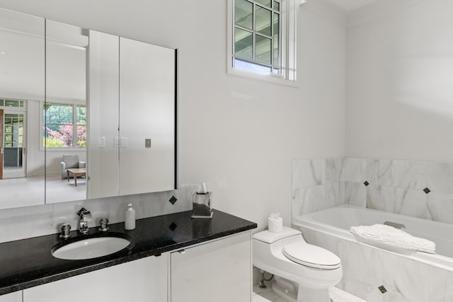 bathroom featuring vanity, a bath, and toilet