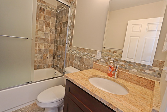 full bathroom featuring combined bath / shower with glass door, vanity, toilet, and backsplash