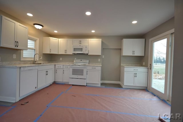 kitchen with white appliances, sink, and white cabinetry