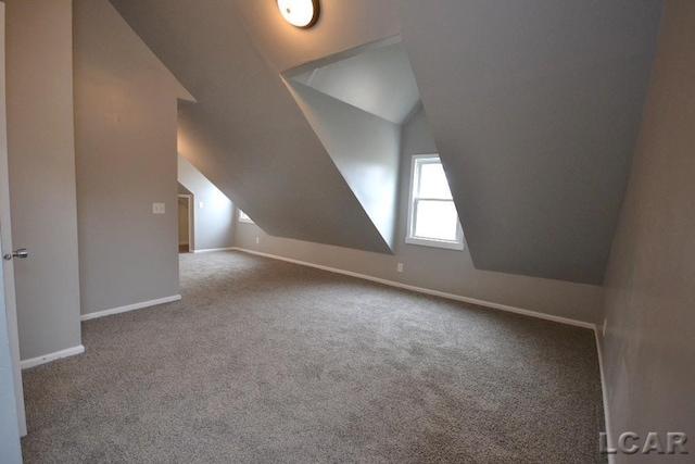 additional living space with vaulted ceiling and carpet