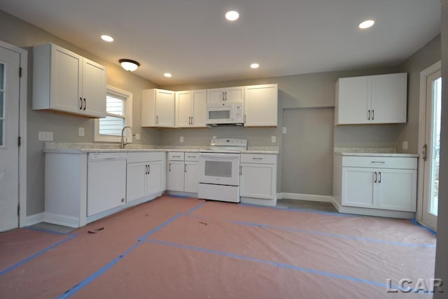 kitchen featuring white appliances, white cabinetry, and sink