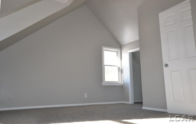 bonus room with vaulted ceiling and carpet floors