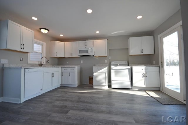 kitchen featuring dark hardwood / wood-style floors, white cabinetry, sink, and white appliances