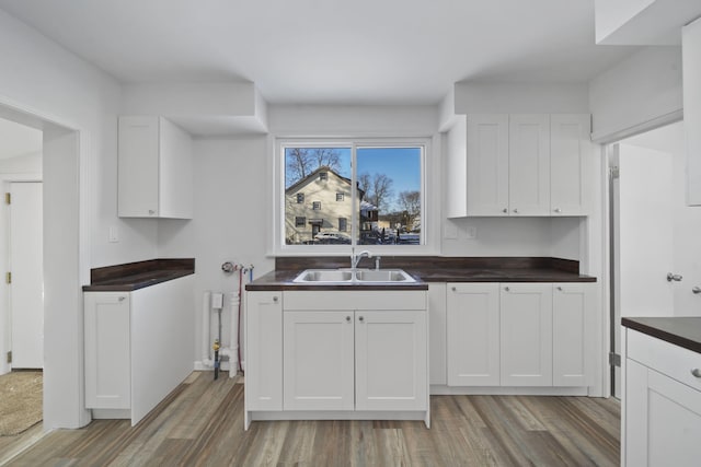 kitchen featuring white cabinets, hardwood / wood-style floors, and sink